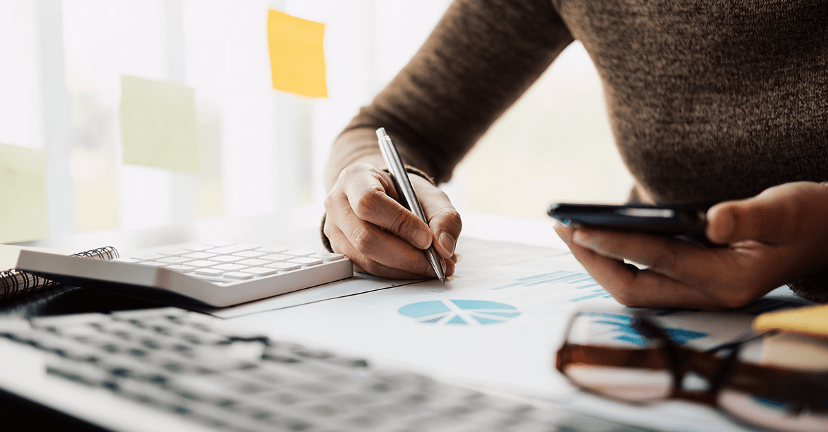 Person checks finances with smartphone and calculator – symbol for digital borrowing and budget planning