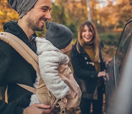 Junge Familie steigt ins Auto – Symbol für finanzielle Freiheit und Fahrzeugfinanzierung mit Autokredit