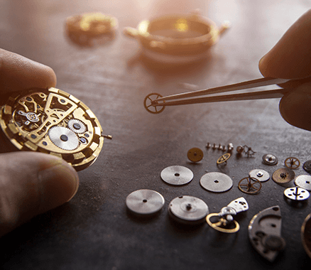Feinarbeit an Uhrwerk – Symbol für individuelle Wünsche, die mit einem Kleinkredit realisiert werden können